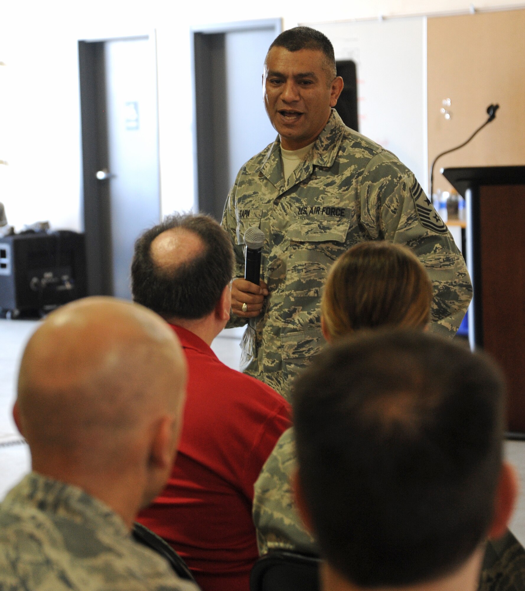 Chief Master Sgt. Gerardo Tapia, command chief of the Air Education and Training Command, speaks to members of the 336th Training Group during a group-wide all-call at the supply warehouse Tuesday, July 2, 2013.  The chief was accompanying Gen. Edward Rice, AETC commander, on a tour of Fairchild Survival, Evasion, Resistance, and Escape facilities.  (U.S. Air Force photo by Staff Sgt. Michael Means/Released)