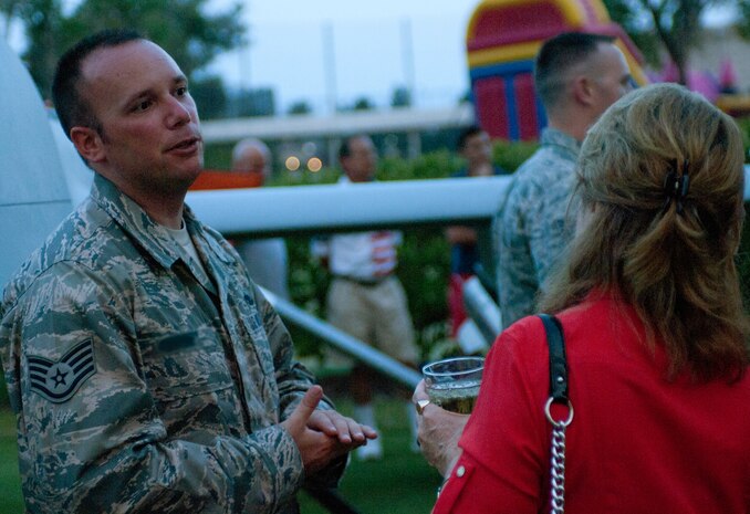 An Airman from the 432nd Aircraft Maintenance Squadron, Las Vegas, discusses some capabilities of the MQ-1 Predator remotely piloted aircraft with the public July 4, 2013, during an Independence Day celebration at the Las Vegas Country Club. Members of the 432nd AMXS attended the event to educate the public on the RPA mission. (U.S. Air Force photo illustration by Airman 1st Class Joshua Kleinholz)  