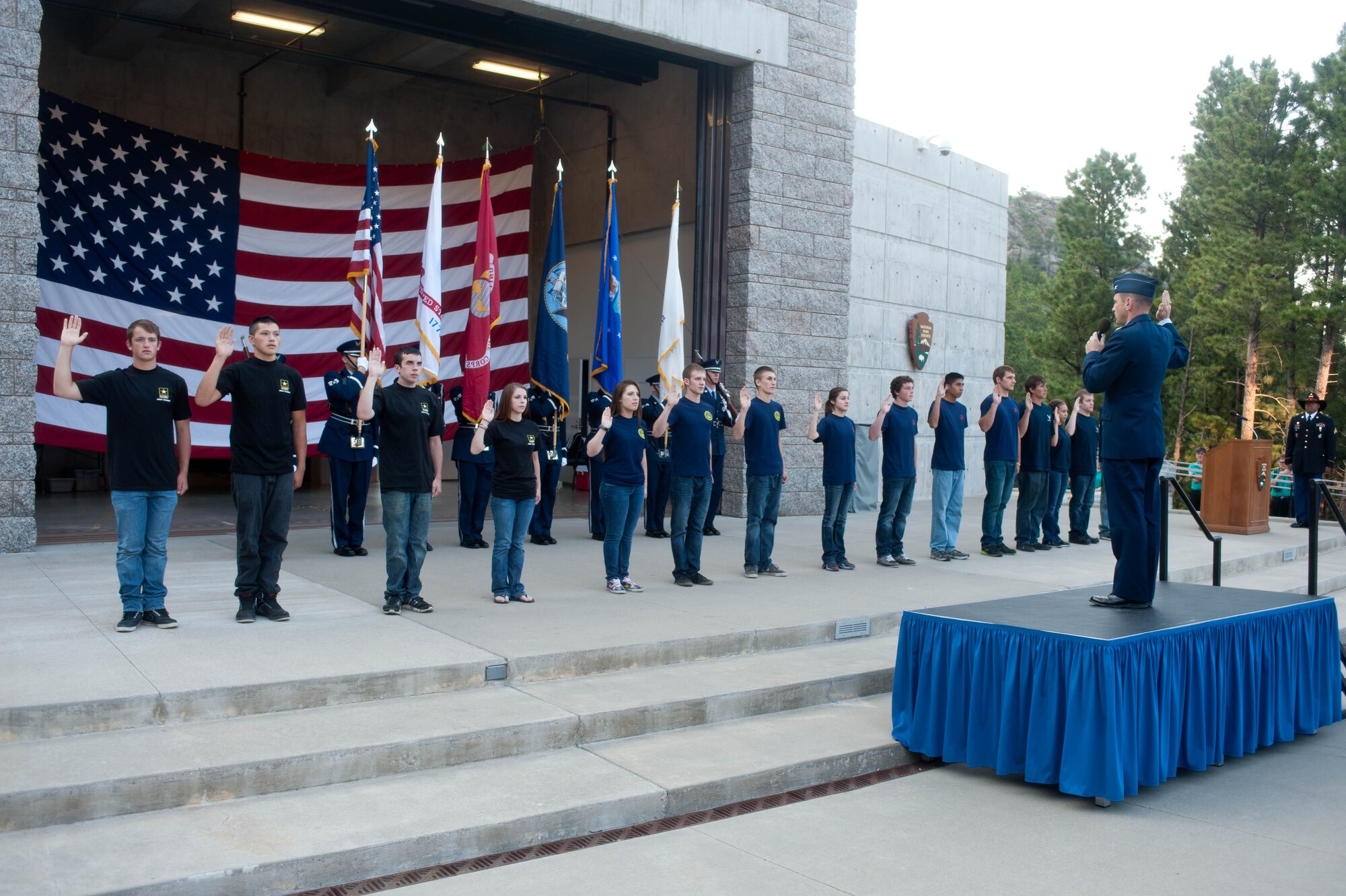 Col. Kevin Kennedy, 28th Bomb Wing commander, administers the oath of enlistment to U.S. military recruits from each branch of service during a military appreciation ceremony held in conjunction with Independence Day activities at the Mount Rushmore National Memorial in South Dakota, July 3, 2013. In addition to witnessing recruits raise their right hands and swear allegiance to defending our nation, hundreds of people from around the globe witnessed a special flag-folding ceremony. (U.S. Air Force photo by Airman 1st Class Zachary Hada/Released)