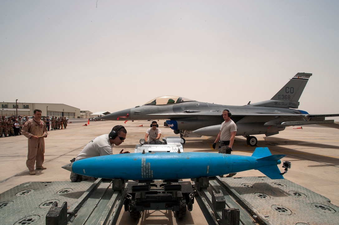 During a practice munitions loading competition, members from the Colorado Air National Guard rush to expediently load an inert practice bomb on an F-16 Fighting Falcon jet in a friendly competition with their Jordanian counterparts the Royal Jordanian Air Force during the Eager Lion exercise. Eager Lion is a U.S. Central Command-directed, irregular warfare-themed exercise focusing on missions the United States and its coalition partners might perform in support of global contingency operations. (U.S. Air National Guard photo by Senior Master Sgt. John P. Rohrer)