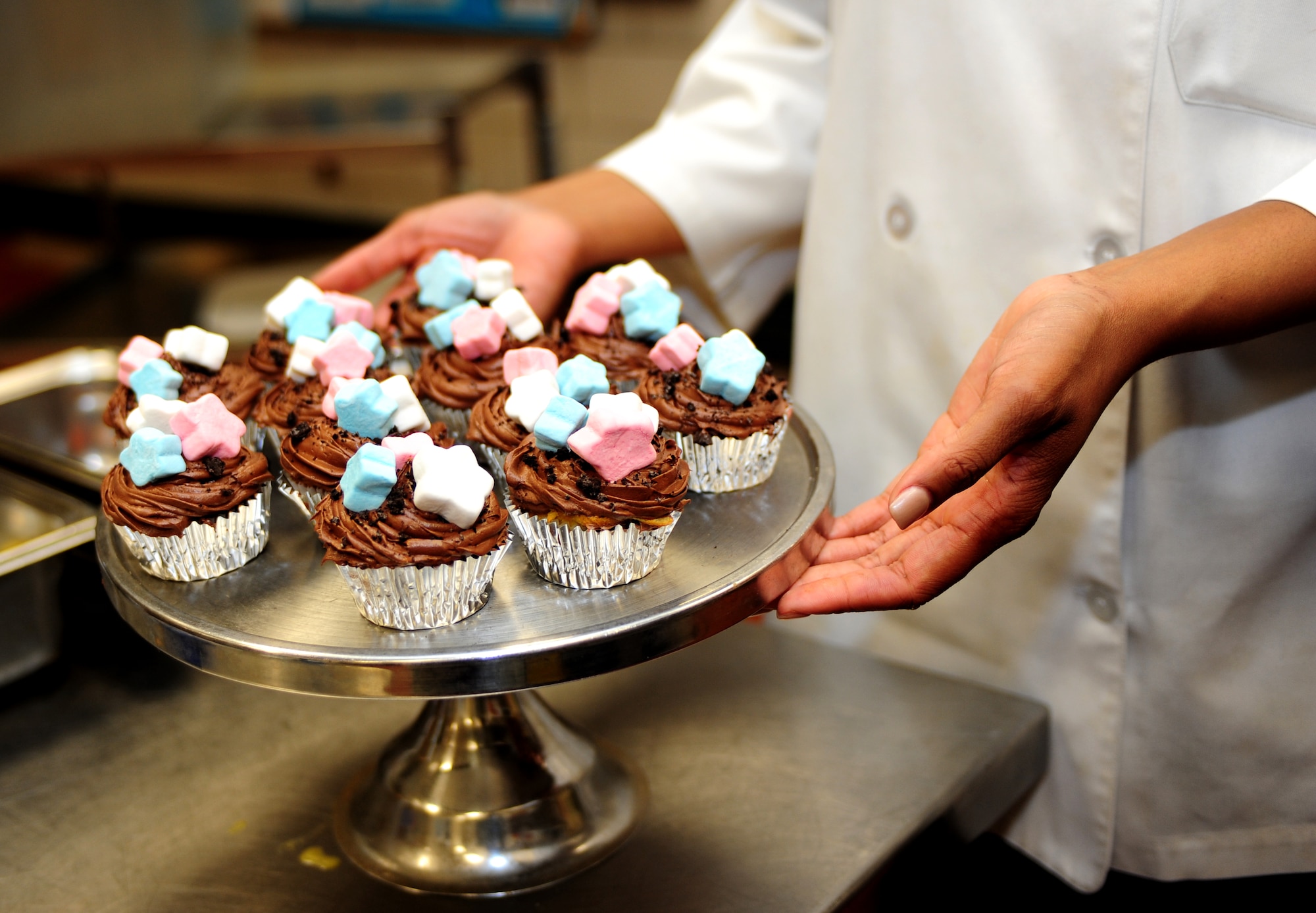 U.S. Air Force Senior Airman Ashli Phillips, 633rd Force Support Squadron chef, takes her team’s cupcakes out to be judged during the 633rd FSS Cupcake Challenge at the Langley Air Force Base Va., Crossbow Dining Facility, July 3, 2013. The 633rd FSS hosts the event to showcase the talent of the squadron’s members. (U.S. Air Force photo by Airman Areca T. Wilson/Released)