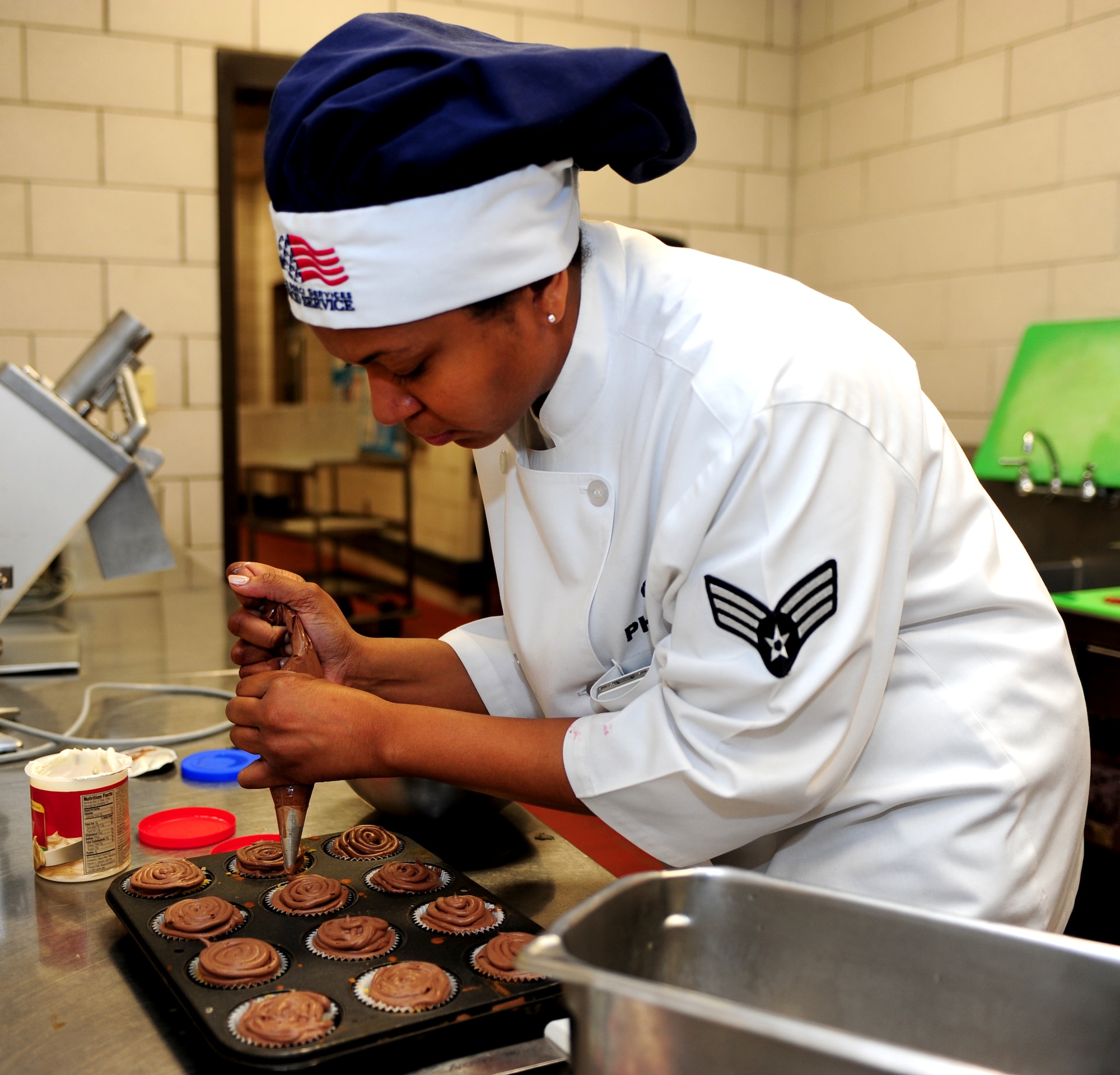 U.S. Air Force Senior Airman Ashli Phillips, 633rd Force Support Squadron chef, decorates cupcakes she and her teammate made during the 633rd FSS Cupcake Challenge at the Langley Air Force Base Va., Crossbow Dining Facility, July 3, 2013. Participants were given two hours to bake and decorate one dozen each of two different flavors of cupcakes, which had to represent the Independence Day theme. (U.S. Air Force photo by Airman Areca T. Wilson/Released)