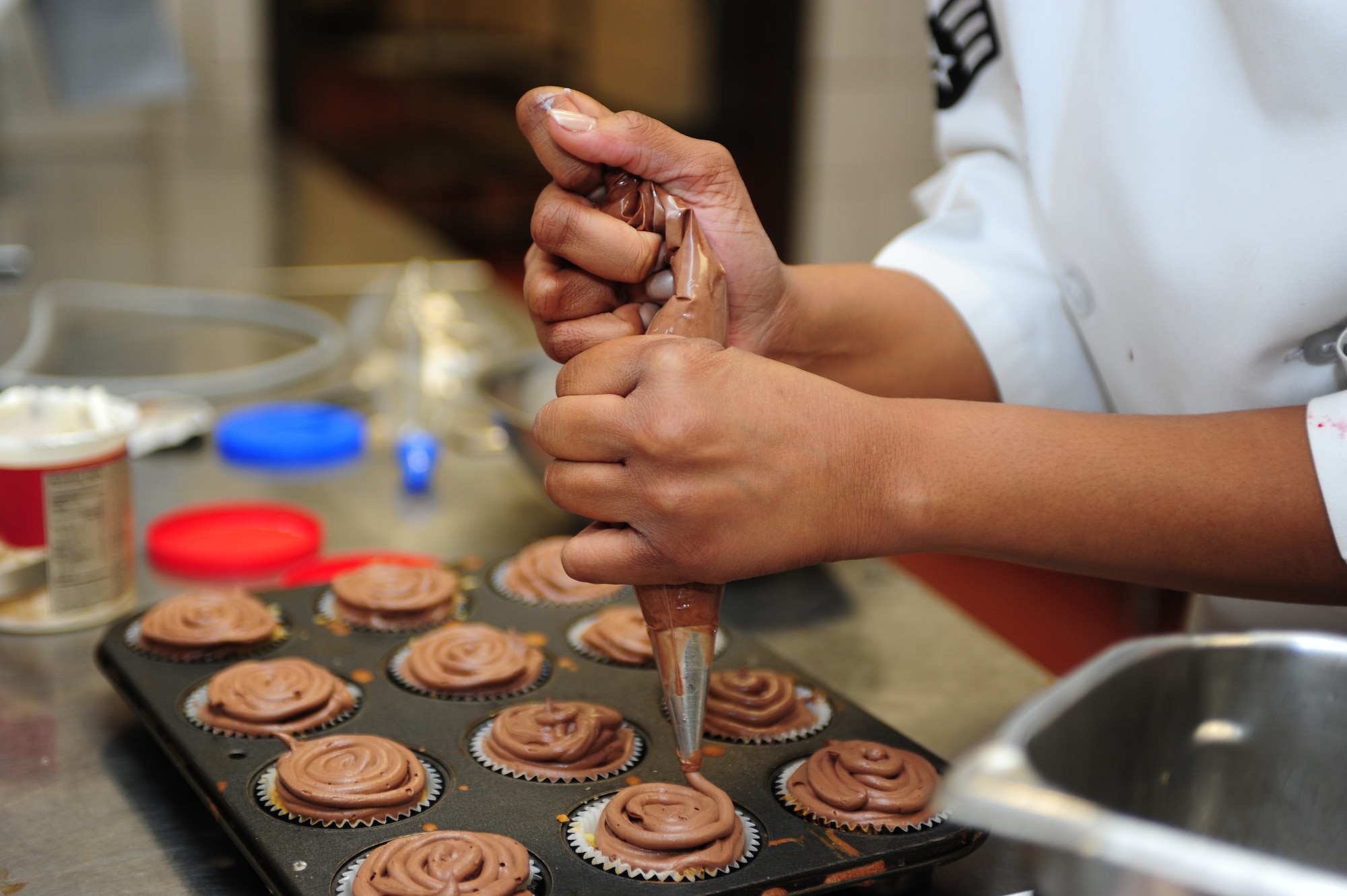 U.S. Air Force Senior Airman Ashli Phillips, 633rd Force Support Squadron chef, decorates cupcakes she and her teammate made during the 633rd FSS Cupcake Challenge at the Langley Air Force Base Va. Crossbow Dining Facility, July 3, 2013. Participants were given two hours to bake and decorate one dozen each of two different flavors of cupcakes, which had to represent the Independence Day theme. (U.S. Air Force photo by Airman Areca T. Wilson/Released)