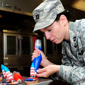 U.S. Air Force Capt. Kady Pauley, 633rd Force Support Squadron sustainment services flight commander, decorates cupcakes during the 633rd FSS Cupcake Challenge at the Langley Air Force Base Va., Crossbow Dining Facility, July 3, 2013. Pauley and her teammate took first place during the competition. (U.S. Air Force photo by Airman Areca T. Wilson/Released)