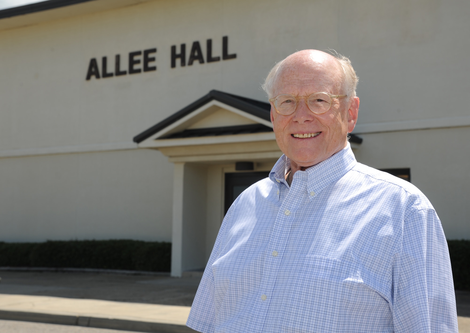 Paul Heintz stands in front of Allee Hall July 9, 2013, following a windshield tour of Keesler Air Force Base, Miss.  Allee Hall was named after Paul’s father, Col. Edward Allee, who died in May 1944 in a plane crash during a training mission.  (U.S. Air Force photo by Kemberly Groue)