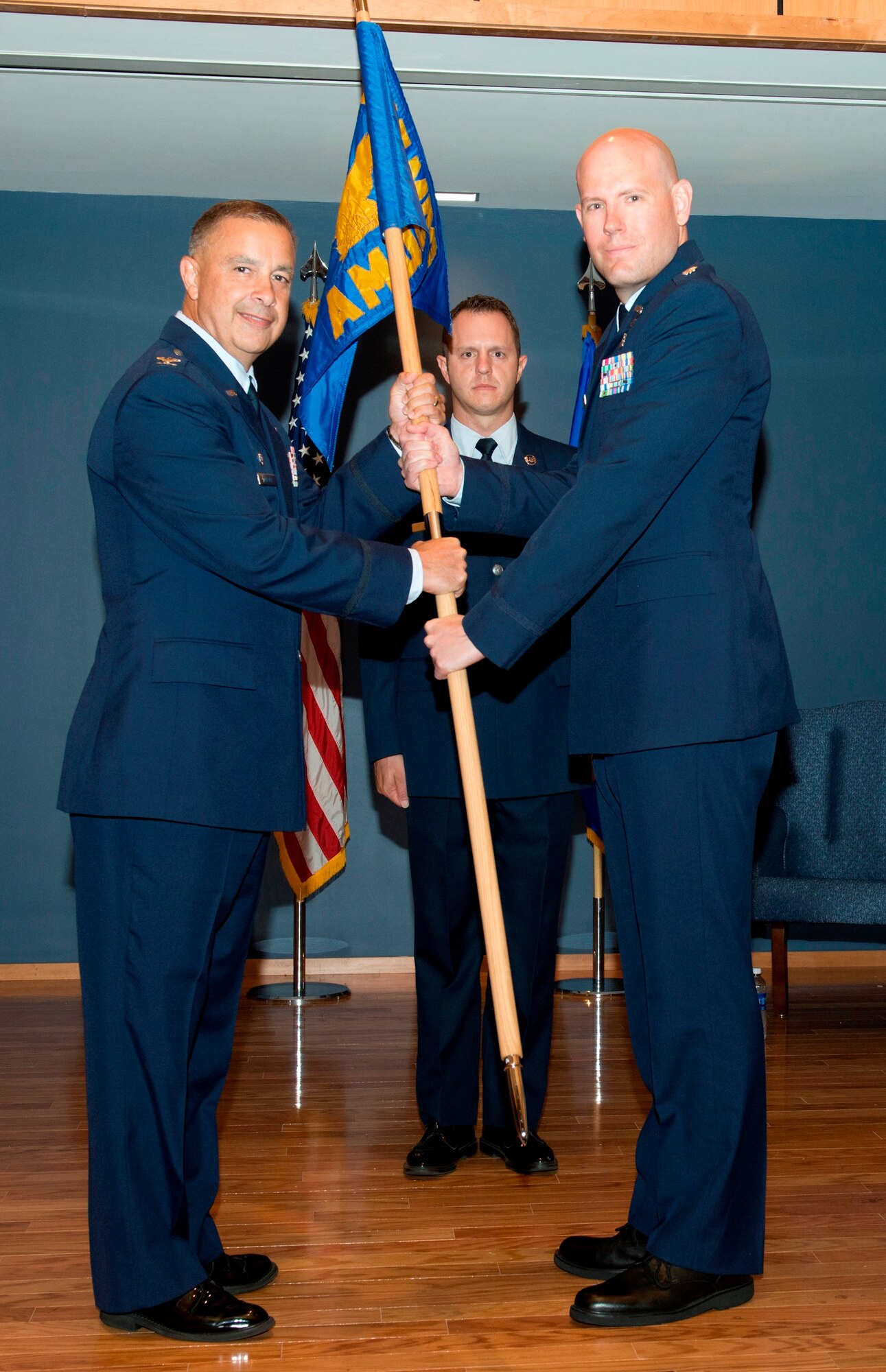 Col. Frederick C. Weaver, 325th Medical Group commander, presents the 325th Aerospace Medicine Squadron  guidon to Lt. Col. Christopher Bird during a change of command ceremony July 9. (U.S. Air Force photo by Lisa Norman)