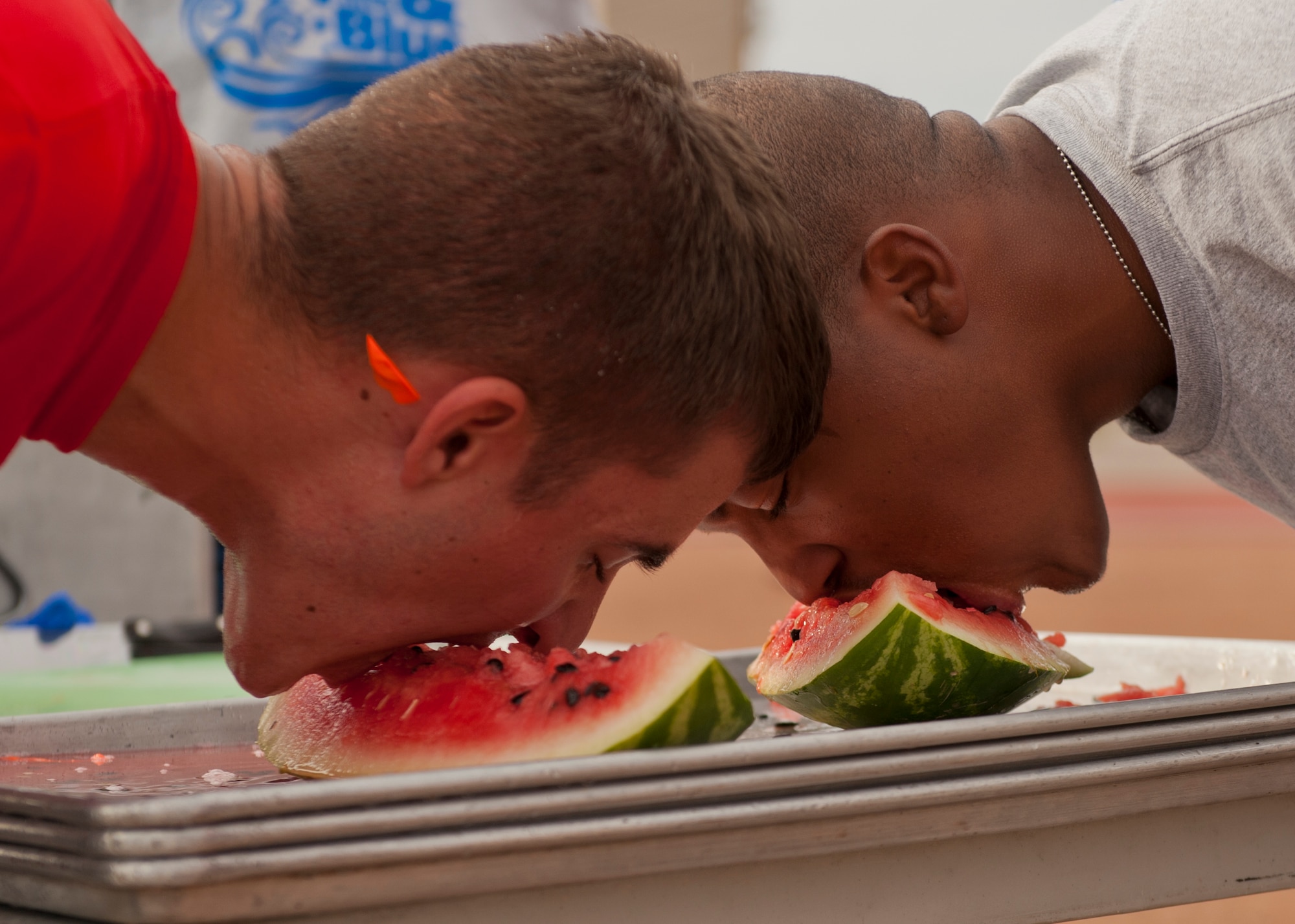 Members of Team Holloman compete in a watermelon eating contest at the Freedom Fest Independence Day celebration at Holloman Air Force Base, N.M., July 3. Freedom Fest took place in the Domenici Fitness and Sports Center parking lot and included carnival games, rides, and live music for Airmen and their families. (U.S. Air Force photo by Airman 1st Class Aaron Montoya/Released)