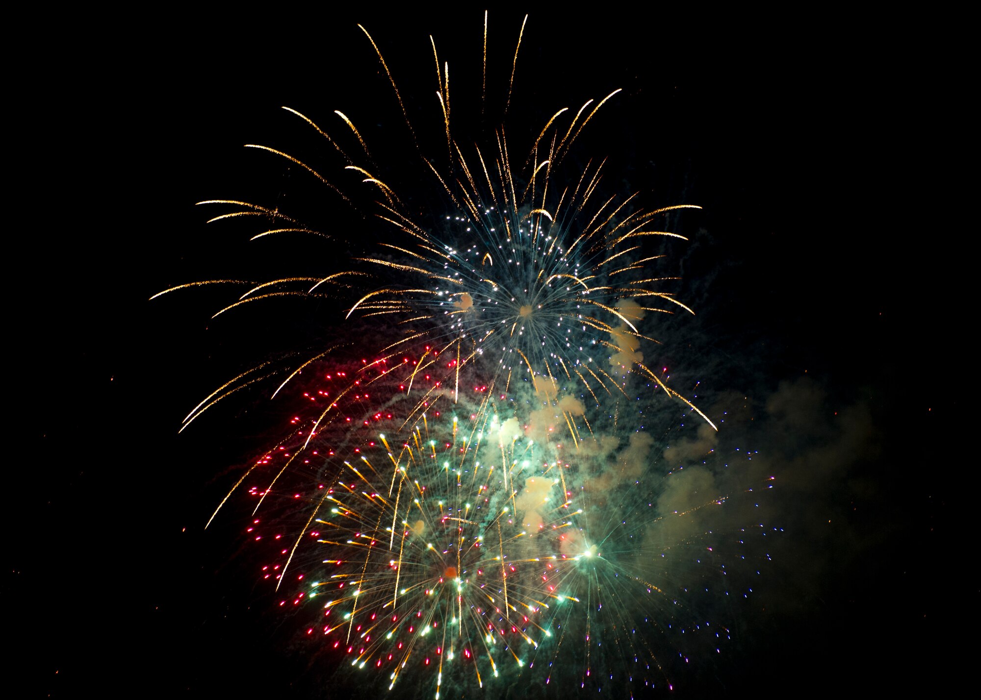 Fireworks bursting in air bring a close to the Freedom Fest Independence Day celebration at Holloman Air Force Base, N.M. July 3. Freedom Fest took place in the Domenici Fitness and Sports Center parking lot and included carnival games, rides, and live music for Airmen and their families. (U.S. Air Force photo by Airman 1st Class Leah Murray/Released)