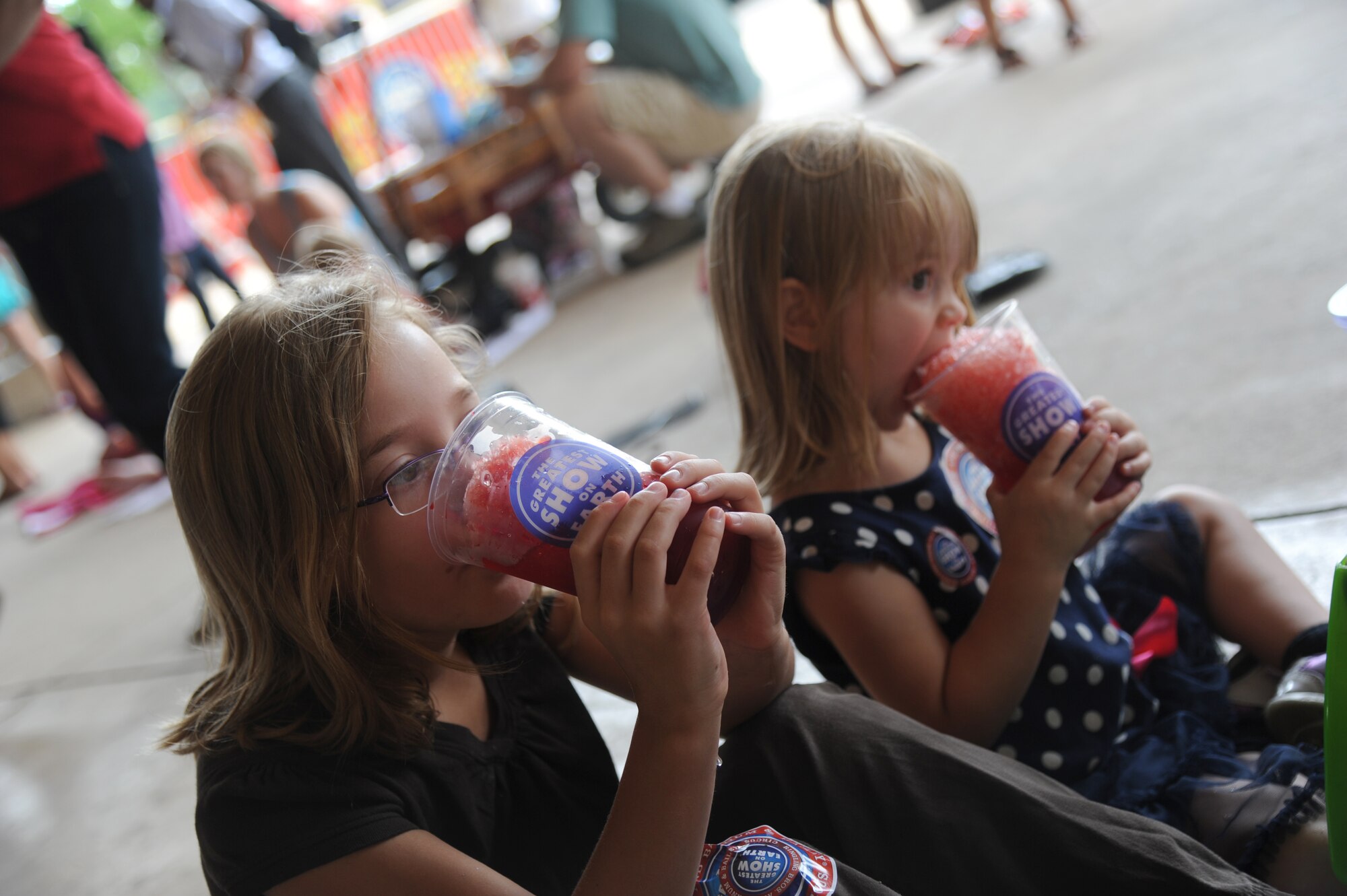 Keesler children eat snowballs during a circus event July 3, 2013, at the Mississippi Coast Coliseum.  Members of Keesler deployed families were invited to participate in a walking parade with the elephants followed by a picnic.  (U.S. Air Force photo by Kemberly Groue)