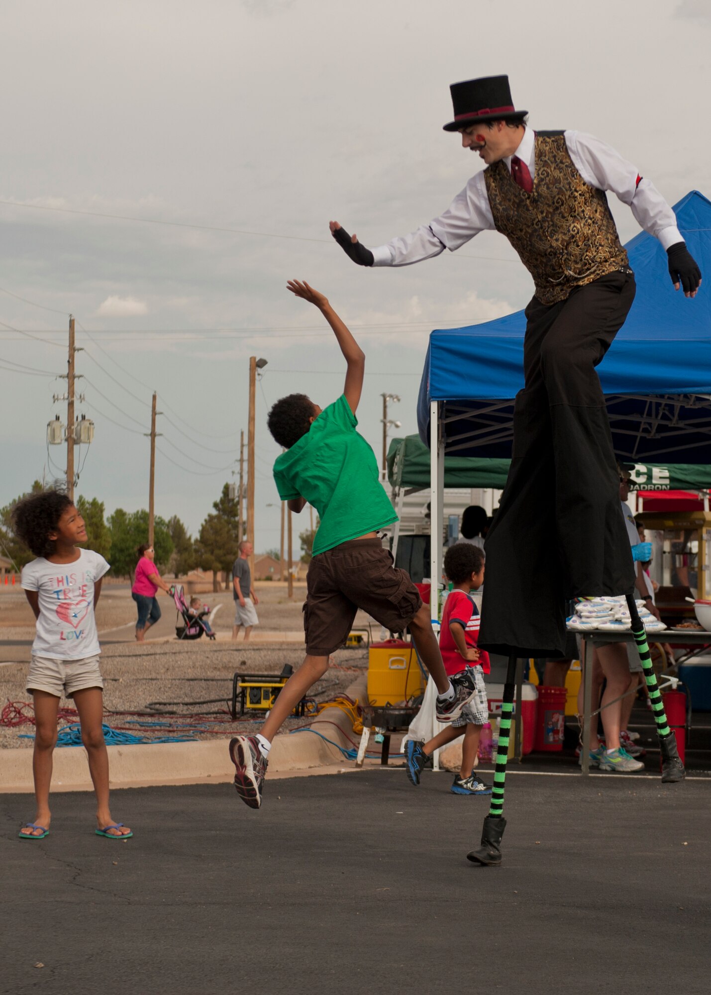 A child leaps for a high five during the Freedom Fest Independence Day celebration at Holloman Air Force Base, N.M., July 3. Freedom Fest took place in the Domenici Fitness and Sports Center parking lot and included carnival games, rides, and live music for Airmen and their families. (U.S. Air Force photo by Airman 1st Class Aaron Montoya/Released)