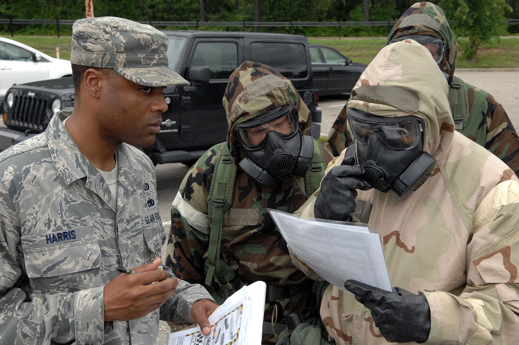 Master Sgt. Neal Harris, left, Exercise Evaluation Team member for the 43rd Airlift Group, asks Senior Airman Quincy Moore, 43rd Logistics Readiness Squadron, right, questions during a unexploded ordinance marking and identification training scenario during the group’s Ability to Survive and Operate Rodeo training on Jul 3, 2013.  During the ATSO Rodeo training, evaluators trained and observed more than 100 Airmen on their ability to survive and operate in a chemical environment.  The evaluators trained and observed Airmen's Mission Oriented Protective Posture gear wear, contamination avoidance, transition and post attack responses, self aid buddy care skills in a contaminated area and contamination control abilities.  The goal of ATSO Rodeo training is to raise awareness and prepare the group for their upcoming operational readiness inspection next year.  (U.S. Air Force photo/Marvin Krause)
