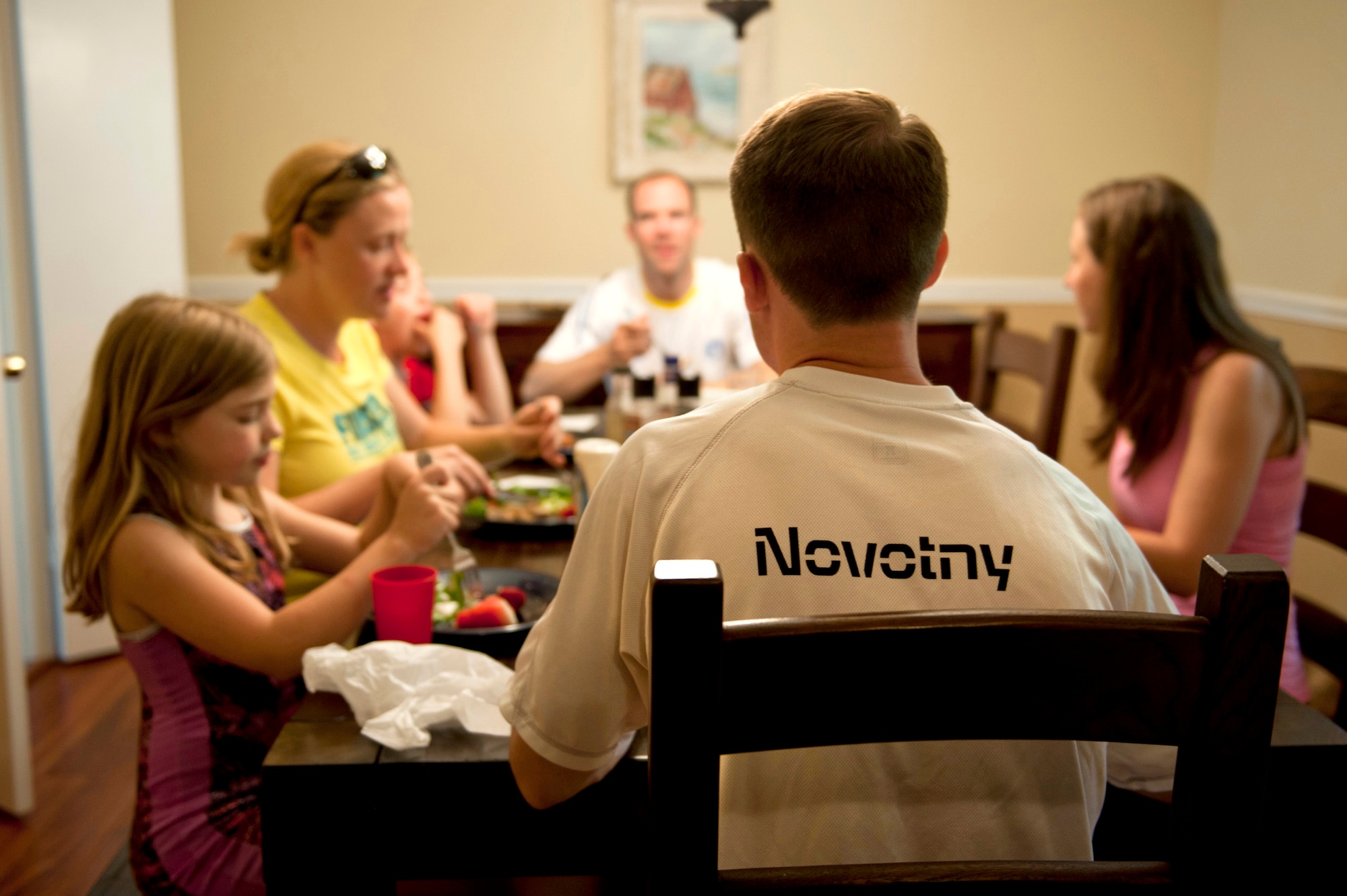 The Novotny family gathers around the table before brothers, Lt. Col. Ryan and Maj. Reid Novotny get together for a marathon run. (Air Force photo/Senior Airman Carlin Leslie)