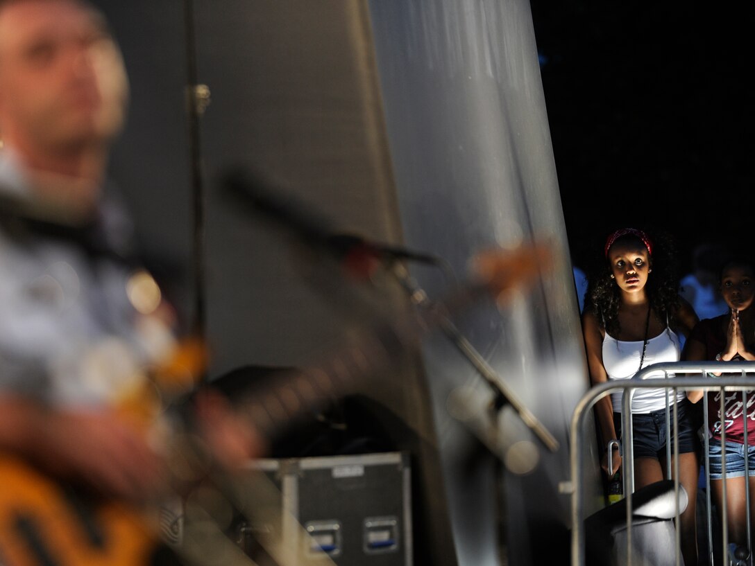 An audience member watches The United States Air Force band perform a rendition of the Edward Sharpe and the Magnetic Zeros song, “Home”, at the Air Force Memorial in Washington, D.C., July 4, 2013.  The band held a performance in honor of the holiday. (U.S. Air Force photo/Airman 1st Class Nesha Humes)