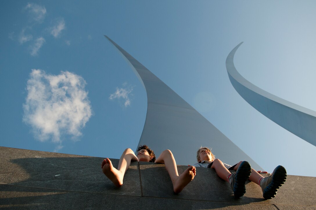 Jackson Gray and Indiana Bradford sit on the Air Force Memorial prior to the 2013 Fourth of July firework show at the Air Force Memorial in Washington, D.C.  Hundreds of people gathered as The United States Air Force Band held a performance in honor of the holiday. (U.S. Air Force photo/Airman 1st Class Nesha Humes)