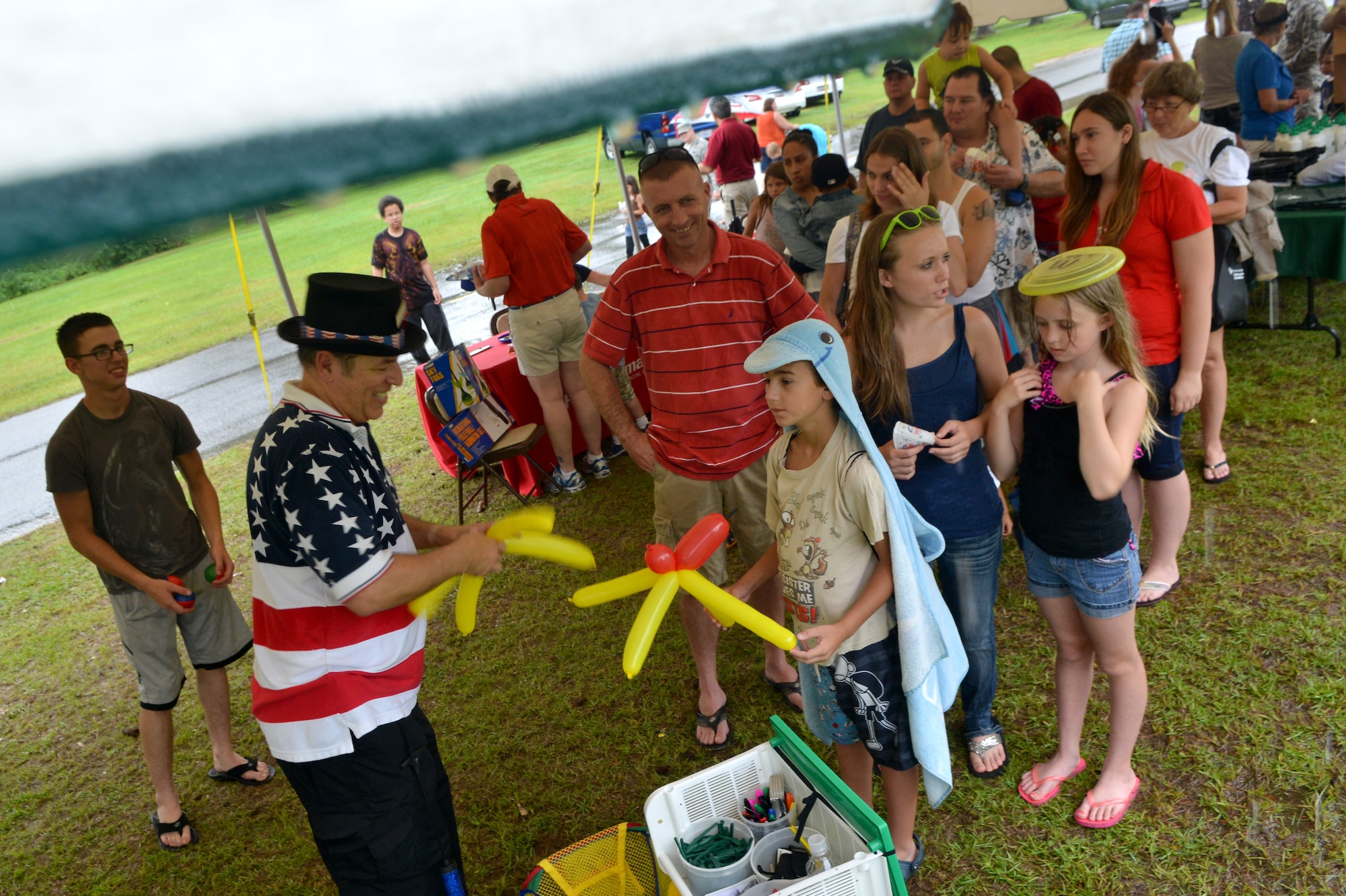 Richard Soos, 20th Security Forces Squadron pass and registration manager, makes  balloon creations for children during the Shaw Freedom Bash, Shaw Air Force Base, S.C., July 3, 2013 Approximately 200 Team Shaw members showed up to the bash despite the inclement weather to kick off the holiday weekend. (U.S. Air Force photo by Airman 1st Class Ashley L. Gardner/Released)