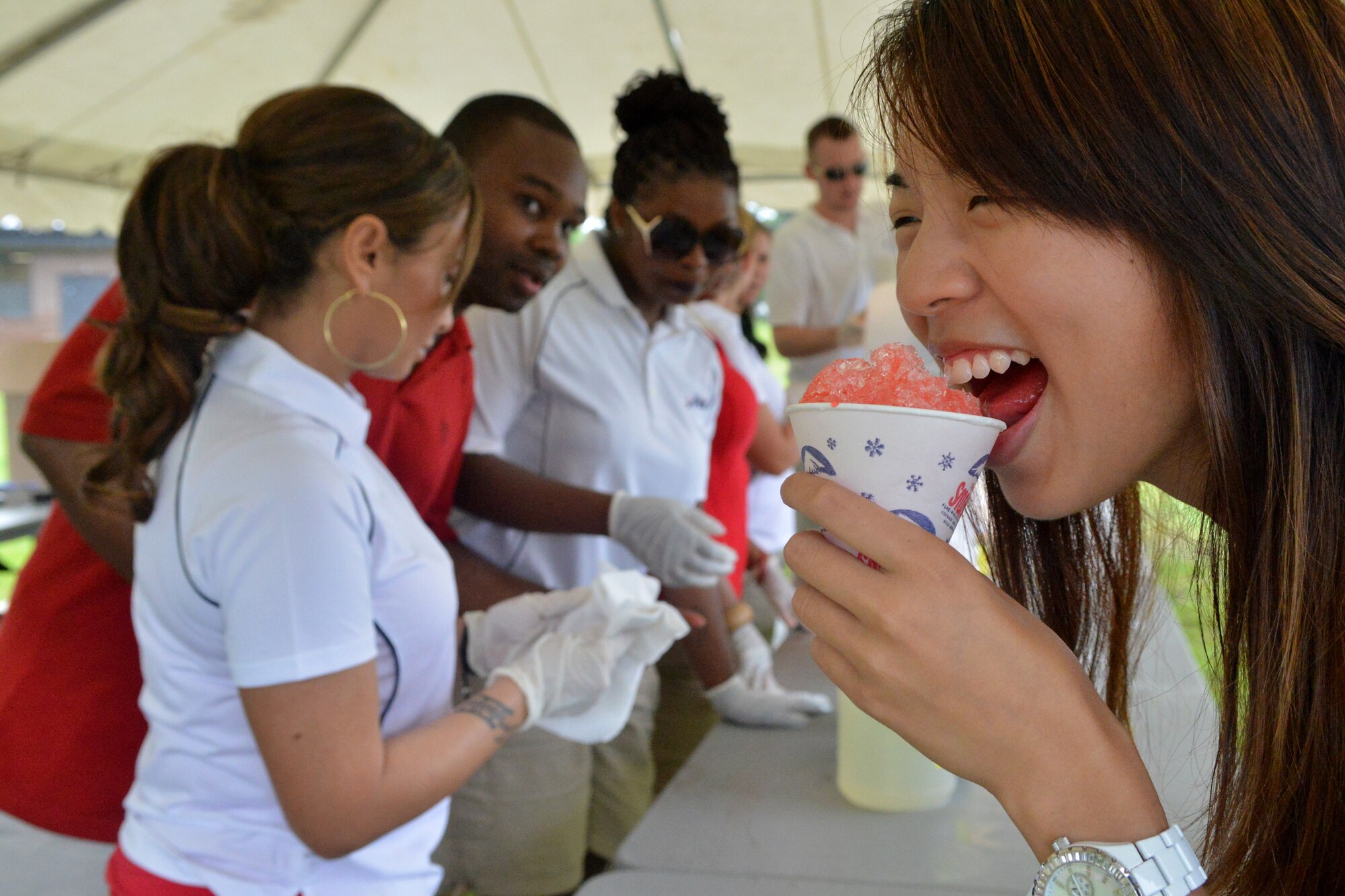 U.S. Air Force Airman 1st Class Josephine Wan, Air Forces Central A-4, samples a snow cone made by 20th Force Support Squadron Airmen during the Shaw Freedom Bash, Shaw Air Force Base, S.C., July 3, 2013. Approximately 300 Team Shaw members showed up to the bash despite the inclement weather to kick off the holiday weekend. (U.S. Air Force photo by Airman 1st Class Ashley L. Gardner/Released)