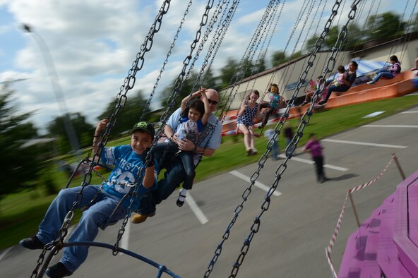 SPANGDAHLEM AIR BASE, Germany – Super Saber Appreciation Day attendees ride a swing July 4, 2013. The 52nd Force Support Squadron sponsored the event to celebrate the U.S. Independence Day and show appreciation to the 52nd Fighter Wing community. (U.S. Air Force photo by Airman 1st Class Gustavo Castillo/Released)