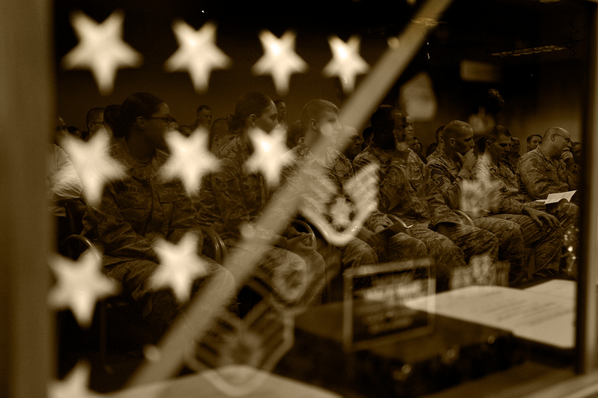 Several U.S. Air Force members of all ranks are reflected in Staff Sgt. Alisha Martell’s career shadow box as they sit in attendance at Martell’s retirement ceremony, March 29, 2013, Shaw Air Force Base, S.C. Martell was an intelligence analyst assigned to Air Forces Central. She retired from active duty due to Thyroid Cancer which she battled throughout her Air Force career. (U.S. Air Force photo by Staff Sgt. Kenny Holston/Released)