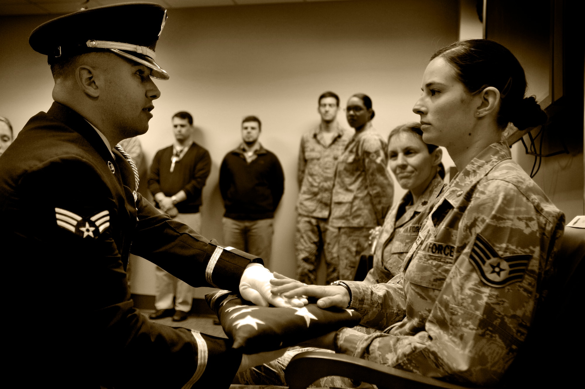 U.S. Air Force Staff Sgt. Alisha Martell, Air Forces Central intelligence analyst, (right) receives a folded American flag from a 20th Fighter Wing honor guard member during her retirement ceremony, March 29, 2013, Shaw Air Force Base, S.C. Martell retired from active duty due to thyroid cancer which she battled throughout her Air Force career. (U.S. Air Force photo by Staff Sgt. Kenny Holston/Released) 