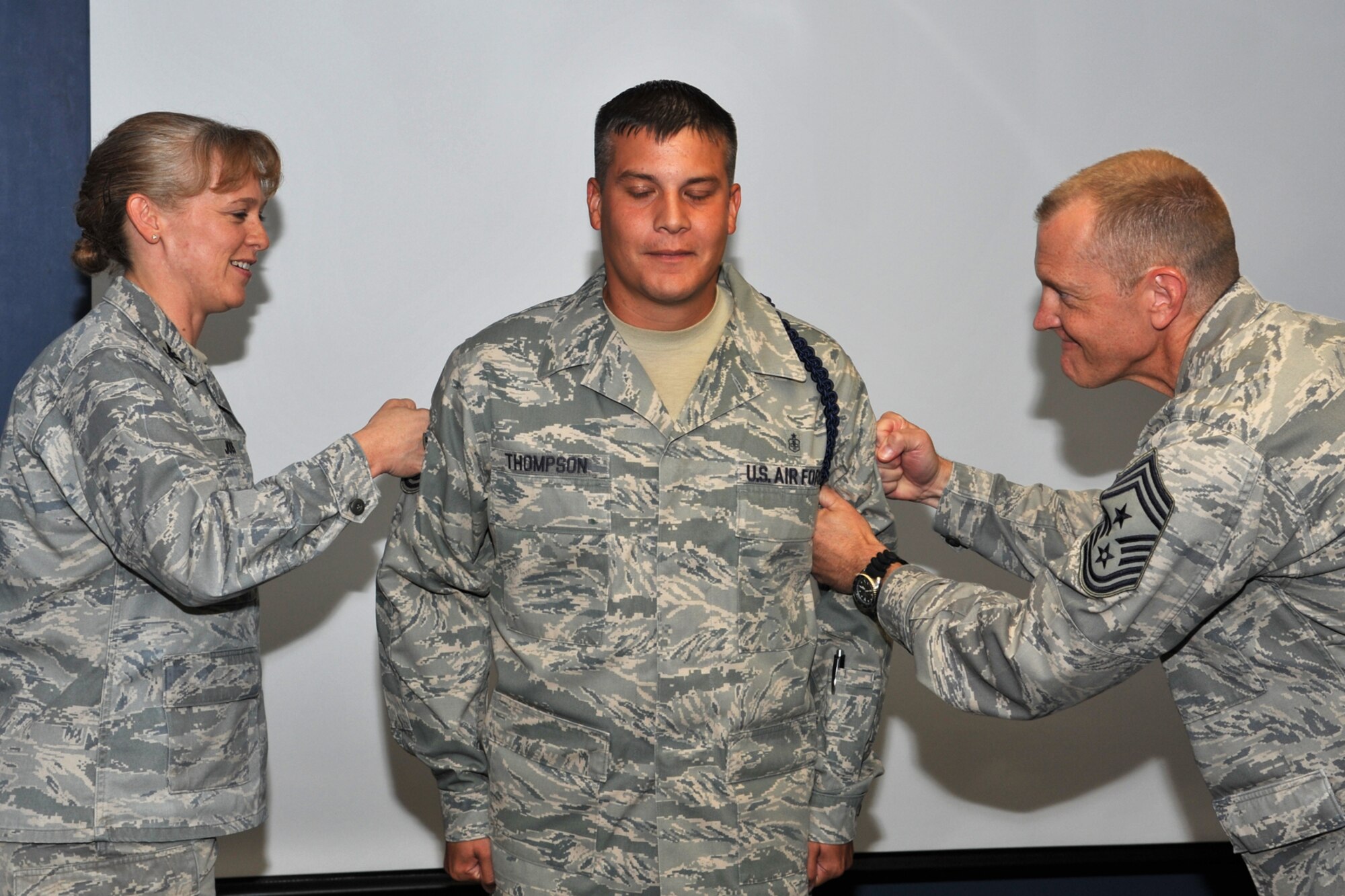 GOODFELLOW AIR FORCE BASE, Texas-- Col. Kimberlee Joos, 17th Training Wing Commander, and Chief Master Sgt. Scott Lumpkin, 17th TRW Command Chief, tack on Staff Sgt. Jacob Thompson, 316th Training Squadron military training leader, the new rank of technical sergeant at the 316th TRS dormitory building June 2. Thompson received his rank through the Stripes for Exceptional Performers program which is a tool commanders can use to promote people that are deserving of immediate promotion. (U.S. Air Force photo/Senior Airman Michael Smith)