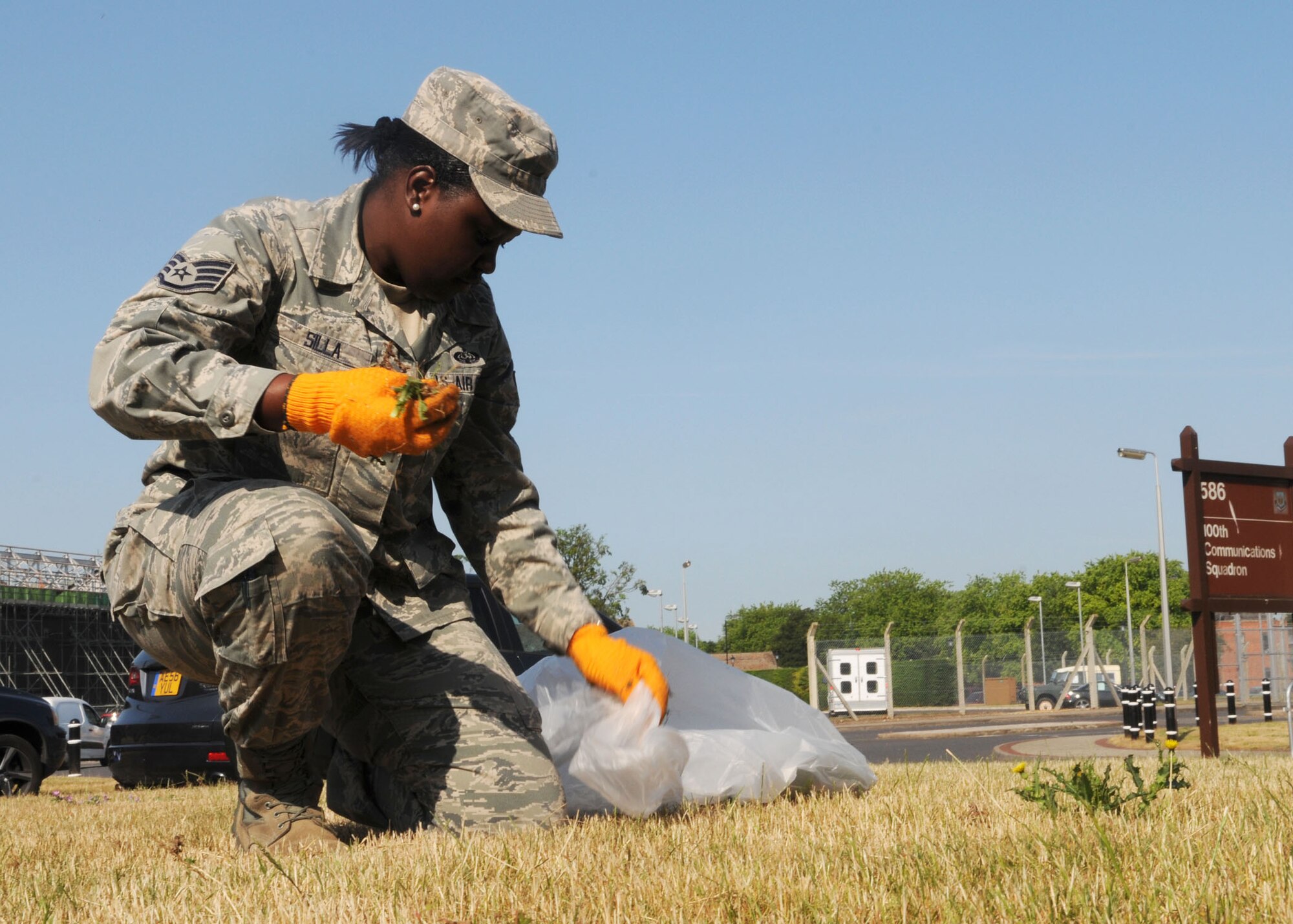 Staff Sgt. Ndeye Silla, 100th Communications Squadron command support staff NCO in charge, picks weeds outside of building 586 during a base cleanup July 9, 2013, on RAF Mildenhall, England.  Members from across Team Mildenhall spent the day weeding and removing trash from the areas surrounding their work centers to keep the base looking its best.  (U.S. Air Force photo by Staff Sgt. Tabitha M. Lee/Released)