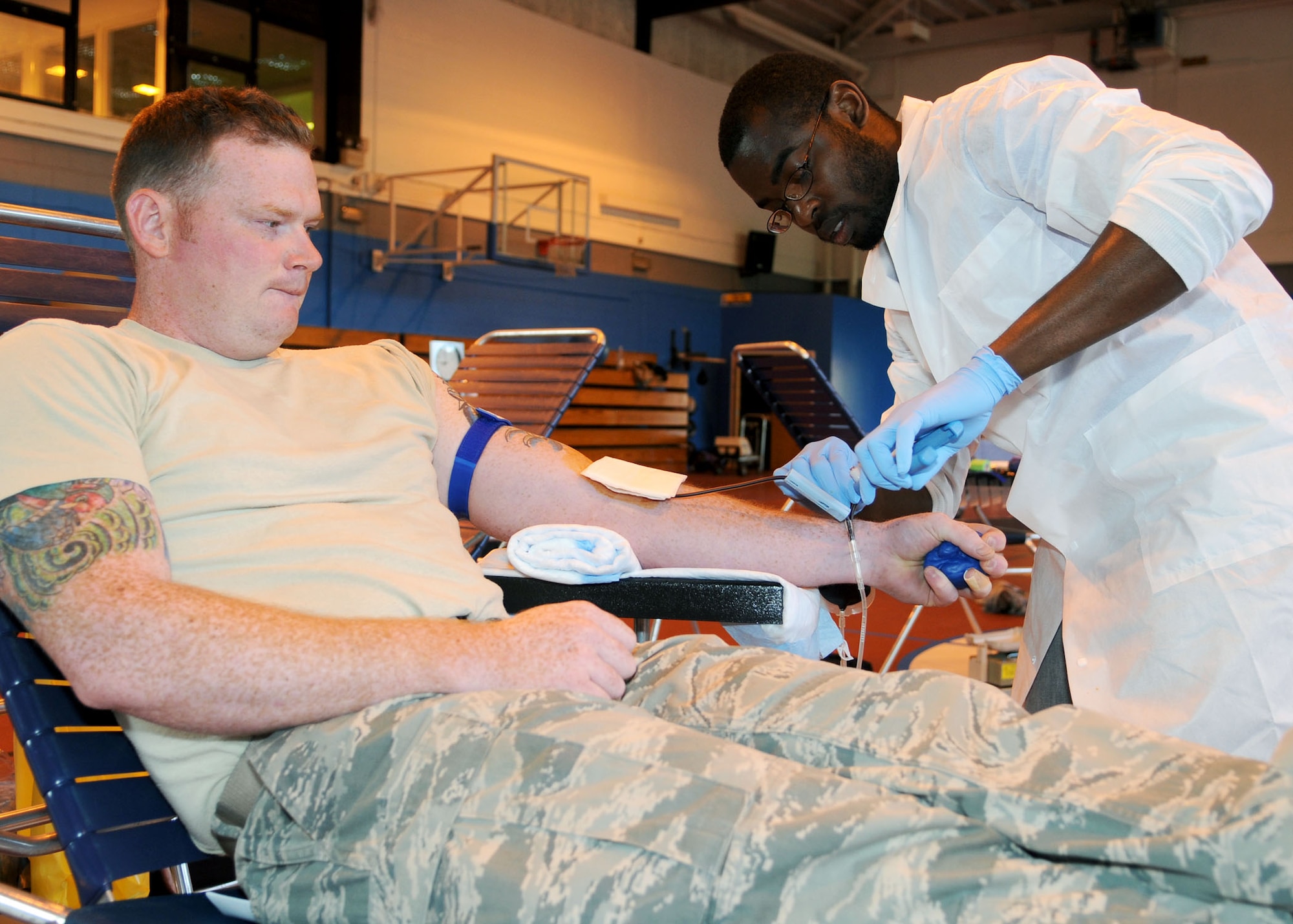 Leonard Little, Landstuhl Regional Medical Center, Germany, medical laboratory technician, draws blood from Staff Sgt. Michael Powers, 373rd Training Squadron KC-135 Stratotanker crew chief instructor, during the Armed Services Blood Program Blood Drive July 9, 2013, on RAF Mildenhall, England. The ASBP’s mission is to provide quality blood products to support worldwide medical readiness requirements and transfusion practices to care for military service members and their families. (U.S. Air Force photo by Staff Sgt. Tabitha M. Lee/Released)