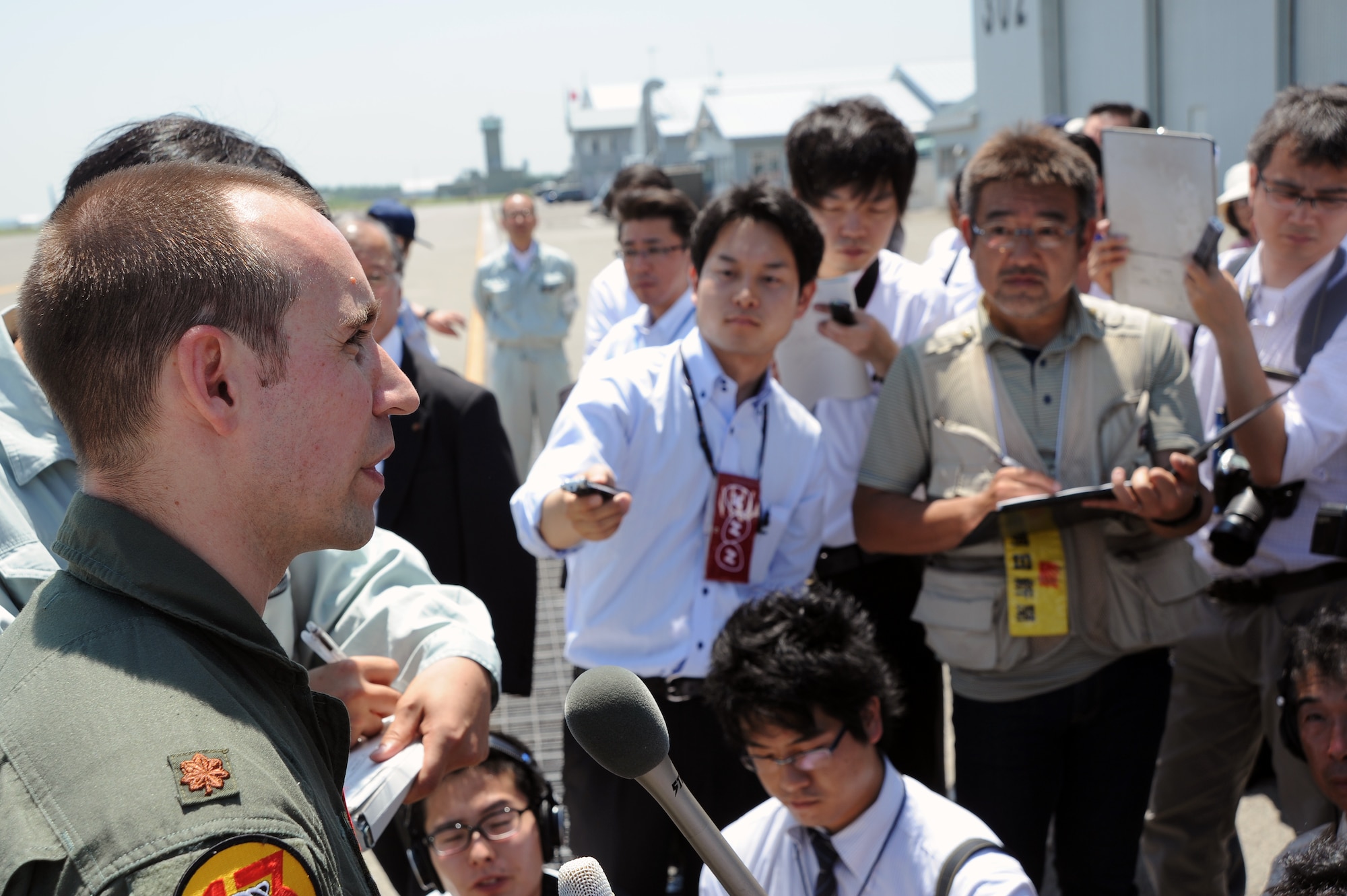 Maj. Jason Mascetta, 13th Fighter Squadron assistant director of operations, fields question from Japanese media members on the flight line at Chitose Air Base, Japan, July 8, 2013. More than 50 members of local city councils and press gathered to gain a better understanding of the training taking place between Airmen from 35th Fighter Wing and the Japan Air Self-Defense Force. (U.S. Air Force photo/Senior Airman Derek VanHorn)