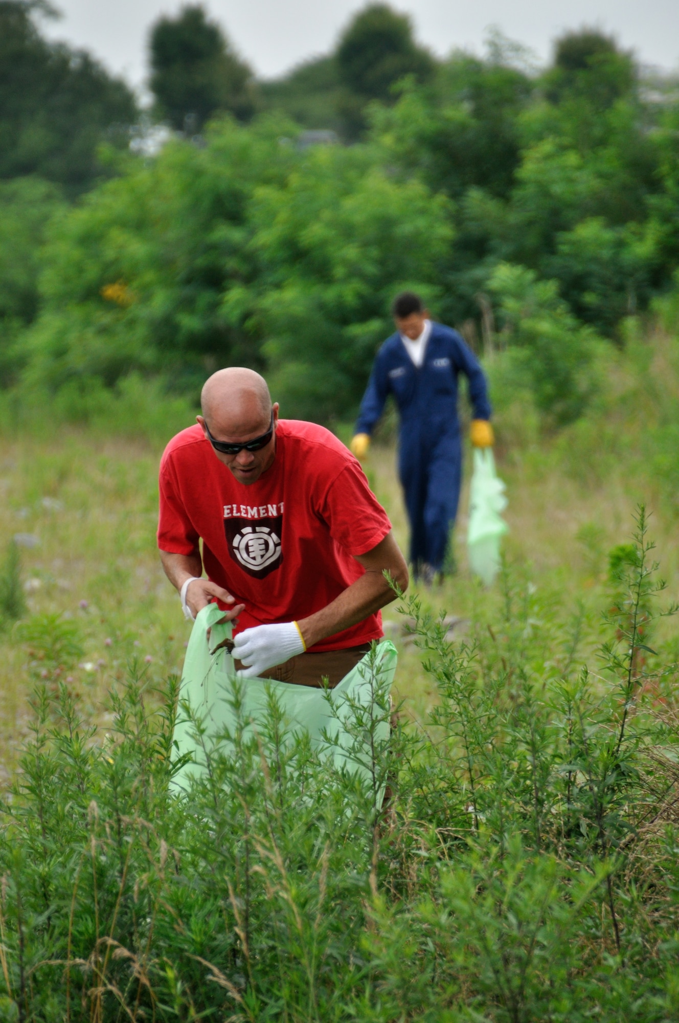 FUSSA, Japan -- Front, Master Sgt. AJ Forbes and Masami Takahashi, both from
374th Logistics Readiness Squadron vehicle management flight, pick up debris
at the Minami Koen park in Fussa, Japan, July 3, 2013. More than 50 people
from the flight participated in the inaugural Adopt-A-Park program clean-up.
(Courtesy photo by Yuichi Yano)
