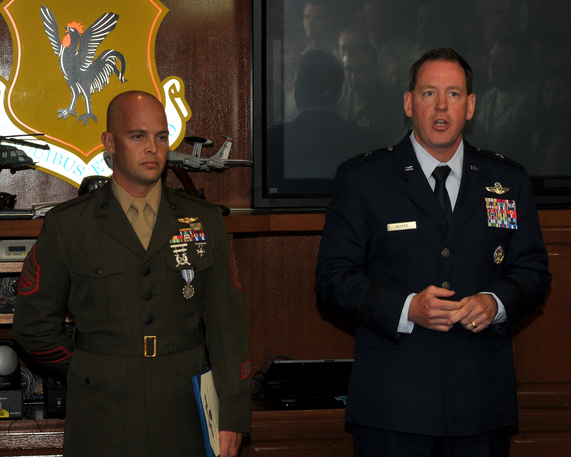 U.S. Air Force Brig. Gen. James Hecker, 18th Wing commander, gives a few words on the actions taken by U.S. Marine Corps Staff Sgt. Ben Whalen after presenting him with the Air Force Achievement Medal on Kadena Air Base, Japan, July 9, 2013. Whalen distinguished himself by outstanding achievement at Hagerstrom pool on June 25, 2013. While swimming with his family Whalen noticed a teenage boy lying motionless on his side at the bottom of the deep end of the pool, expelling what appeared to be bodily fluids from his mouth. Without hesitation Whalen swam down to the victim, and with the aid of another rescuer, pulled the victim to the surface. Upon reaching the edge of the pool, he yelled for assistance, helped maneuver the victim out of the water, instructed the nearest lifeguard to call 911, and proceeded to assist with Cardio Pulmonary Resuscitation until medical responders arrived. Whalen’s decisive actions and selfless act of courage saved the victim’s life and reflected credit upon himself and the United States Marine Corps. (U.S. Air Force photo by Staff Sgt. Laszlo Babocsi/Released)