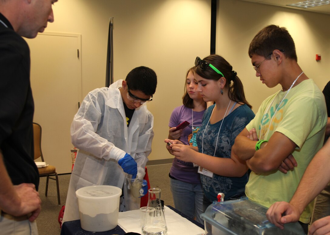 Students at an Army STEM Exposition create test samples using rapid set runway repair cement developed by Engineer Research and Development Center. 