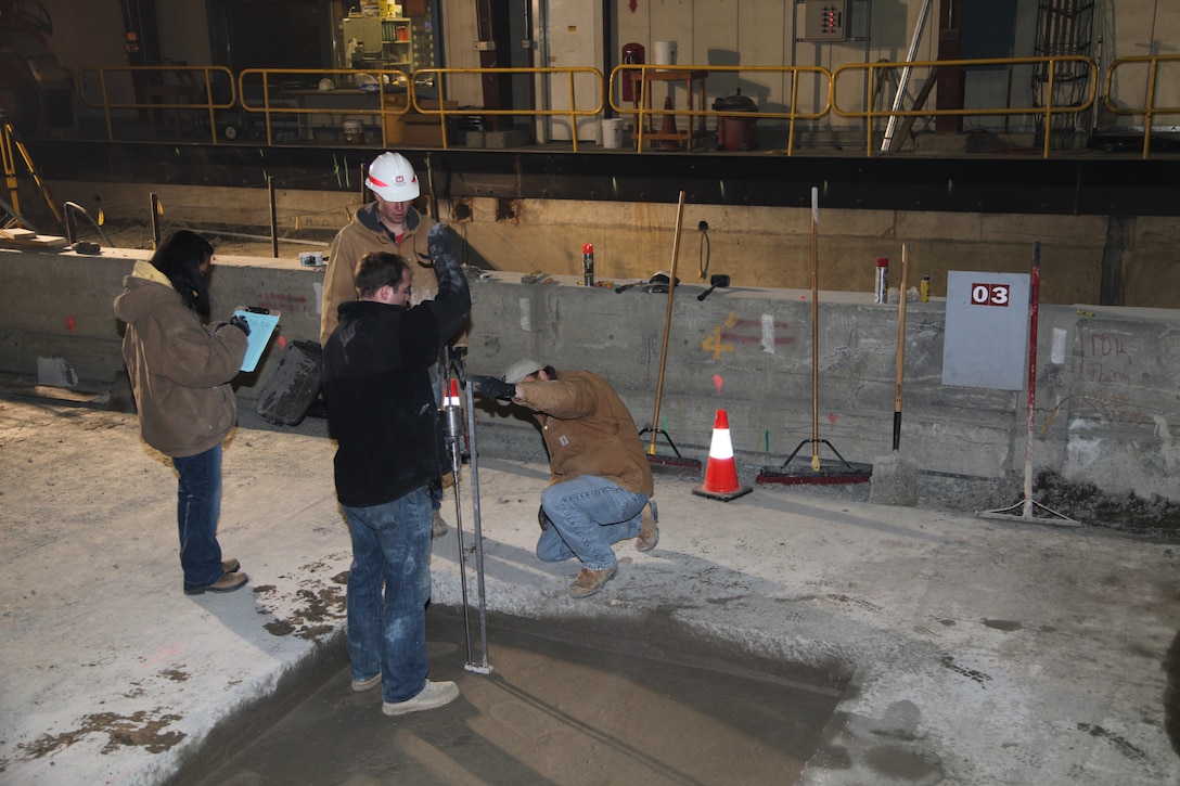 Researchers with ERDC’s Geotechnical and Structures Laboratory and Cold Regions Research and Engineering Laboratory (CRREL) take initial data for cold weather testing on new airfield damage repair materials in CRREL's Frost Effects Research Facility. 
