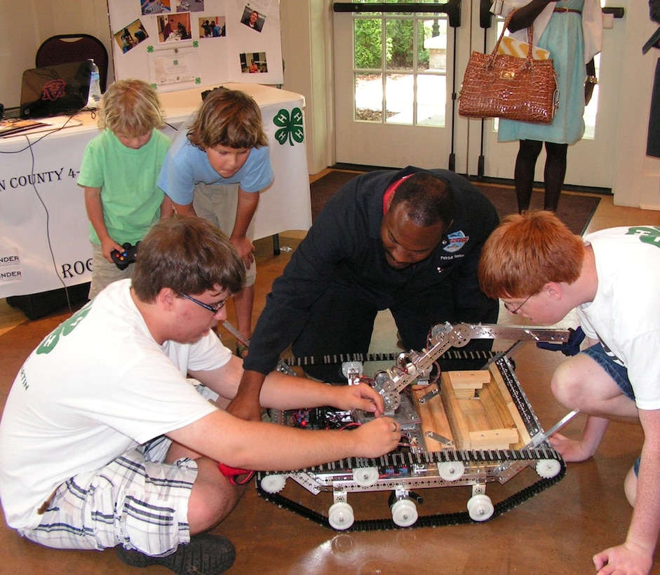 Dr. Patrick Taylor, center, an engineer at the Aviation and Missile Research Development and Engineering Center, explains robotic principles to Madison County 4-H Robotics team members during the Tennessee Valley Jazz Society's Science and Arts Symposium. Thursday's event was part of the 27th Tennessee Valley Jazz-N-June Festival held June 15-23