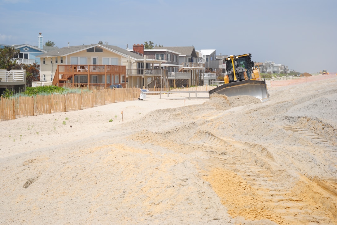 A bulldozer pushes sand on Long Beach Island, NJ, July 2, as part of a U.S. Army Corps of Engineers project. The Corps' Philadelphia District is managing the project. In total, more than 26 million cubic yards of sand will be placed along the coastline throughout the northeastern United States to restore coastal storm risk reduction projects previously built by the Corps that were severely impacted by Hurricane Sandy. The bulk of the sand, roughly 23 million cubic yards, will be placed in New York and New Jersey.