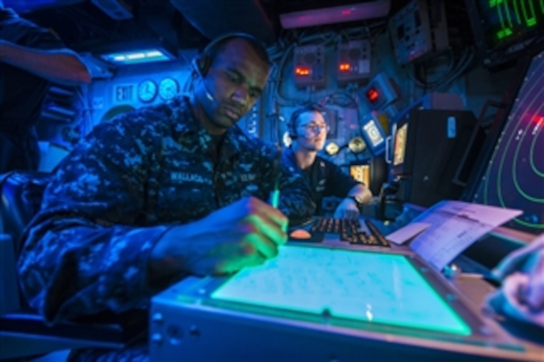 U.S. Navy Petty Officers 2nd Class Timothy Wallace, left, and Clayton Alexander observe radar signatures in the air traffic control room of the amphibious assault ship USS Bonhomme Richard (LHD 6) as the ship operates in the Coral Sea on July 6, 2013.  Wallace and Alexander are Navy air traffic controlmen.  The Bonhomme Richard Amphibious Ready Group is conducting joint force operations in the U.S. 7th Fleet area of responsibility.  