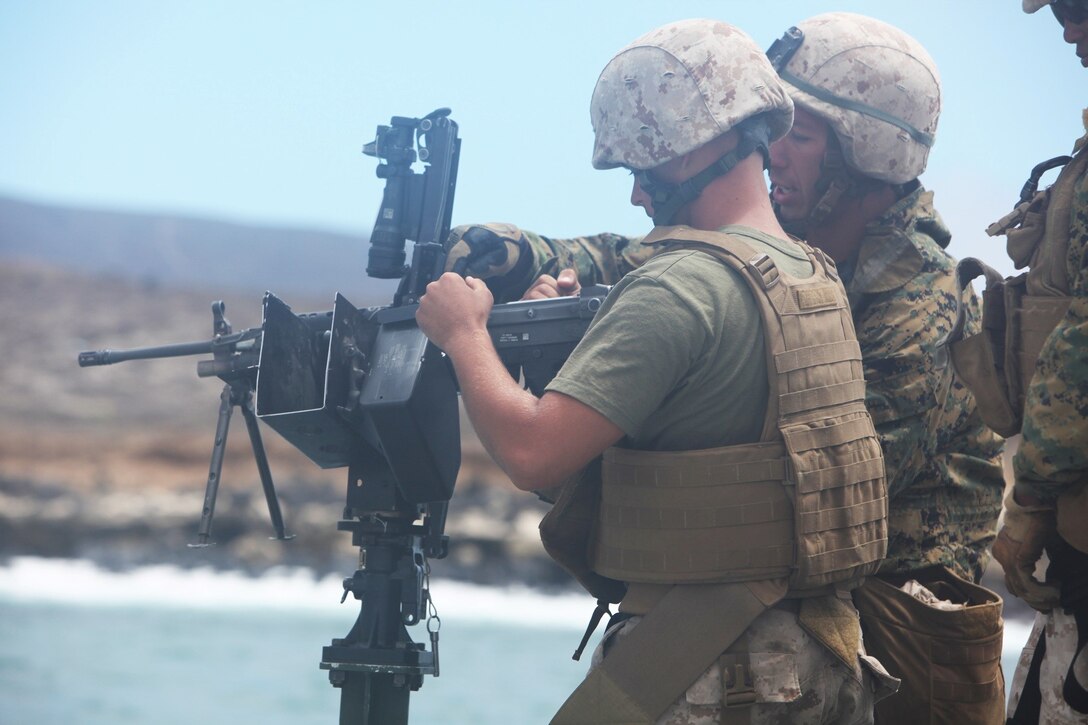 Marines with Bridge Company, 7th Engineer Support Battalion, 1st Marine Logistics Group, reload an M249 squad automatic weapon during a field training exercise at San Clemente Island, Calif., June 27, 2013. The Marines fired M249 SAWs from a moving platform to 
familiarize themselves with the weapon should they have to engage targets during bridging operations during future deployments.