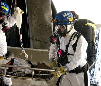 Members of FEMA Task Force 1 from Dayton, Ohio, carry a simulated victim to safety in the collapsed garage at Muscatatuck Urban Training Center on July 17th during Vibrant Response, a U.S. Army North national emergency response exercise designed to create the realism of an American city following a nuclear blast. (U.S. Army photo by Staff Sgt. Brad Staggs)