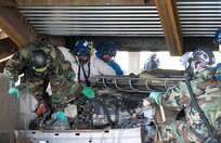 Soldiers from the 392nd Chem. Co. out of Little Rock, Ark., work alongside FEMA Task Force 1 from Dayton, Ohio, to find simulated victims in the collapsed garage at Muscatatuck Urban Training Center on July 17th during Vibrant Response, a U.S. Army North national emergency response exercise designed to create the realism of an American city following a nuclear blast. (U.S. Army photo by Staff Sgt. Brad Staggs)
