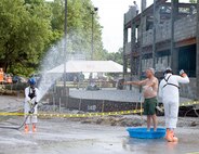 Floyd McTarsney of Franklin, Ind., is decontaminated by members of FEMA Task Force 1 from Dayton, Ohio, after he is "found" in the collapsed garage at Muscatatuck Urban Training Center on July 17th during Vibrant Response, a U.S. Army North national emergency response exercise designed to create the realism of an American city following a nuclear blast. (U.S. Army photo by Staff Sgt. Brad Staggs)