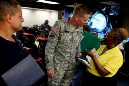 Jonetta Darden, Territory Public Assistance Officer, confers with Army Col. Robert Freehill, Defense Coordinator, and John Alonzo Federal Emergency Management Agency Logistics Chief in the Virgin Islands Territory Emergency Operations Agency center as Hurricane Earl bears down on the Island. Rapid and accurate sharing of response information between the local responders and state and federal officials is vital during an emergency or disaster. 

