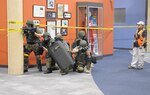 Jesus Ramirez, (right) controller, Civil Support Training Activity, U.S. Army North, watches members of the Richfield special weapons and tactical unit clear out notional hostiles who unleashed a biological weapon during a simulated attack at the Best Buy Corporate Headquarters building here Aug. 25. Members of Army North’s Civil Support Training Activity team out of San Antonio, Texas, deployed to Minneapolis during the pre-evaluation training exercise in support of the 55th Civil Support Team, which was called upon by the local Richfield County police and fire departments to help decontaminate a crime scene. The 55th CST is a Minnesota Army National Guard unit based out of Fort Snelling, Minn. 

