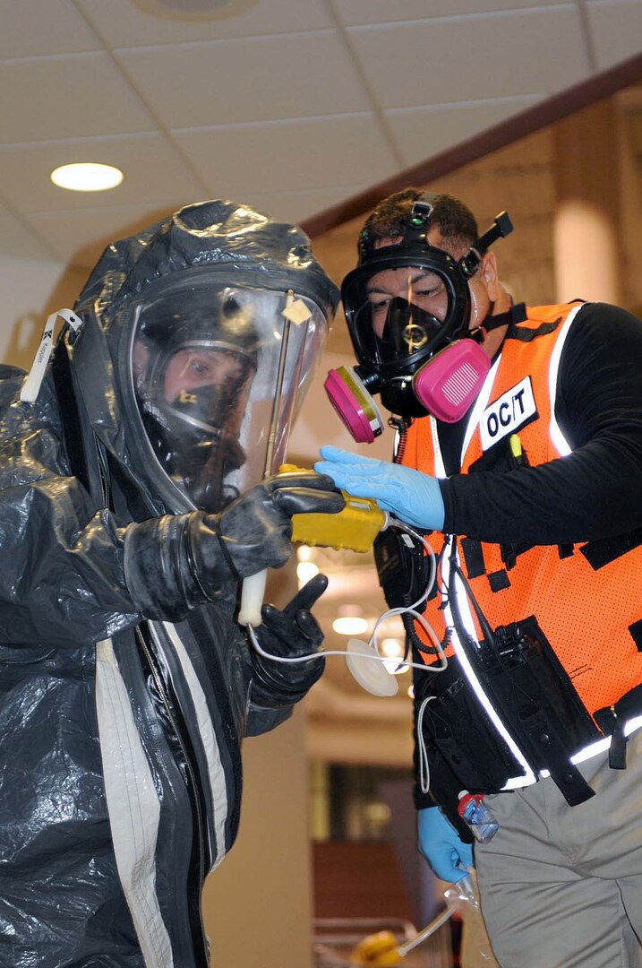 Javier Rodriguez-Ramos (right), observer controller, Civil Support Training Activity, U.S. Army North, assists a member of the 55th Civil Support Team as he determines the amount of chemical exposure from a notional briefcase containing simulated anthrax by using a chemical detection device during the pre-evaluation training exercise here Aug. 25. Members of Army North’s Civil Support Training Activity team out of San Antonio, Texas, deployed to Minneapolis during a pre-evaluation training exercise in support of the 55th CST, which was called upon by the local Richfield County police and fire departments to help decontaminate a crime scene. The 55th CST is a Minnesota Army National Guard unit based out of Fort Snelling, Minn. 

