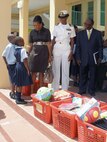 Two Bahamian students greet U.S. Ambassador Nicole Avant, Navy Lt. Cmdr. Janice Smith and Howard Newbold, District Superintendent for the North Western District, on arrival at Woodcock Primary School Sept. 9. U.S. Northern Command funded $6,000 in school supplies for local schools as part of its longstanding partnership with the people of The Bahamas and demonstrates the Department of Defense’s commitment to helping to strengthen communities and build partnerships around the world. 

