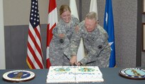 Army Capt. Christina Taylor, North American Aerospace Defense Command and U.S. Northern Command J7, and Army Lt. Gen. Frank Grass, USNORTHCOM deputy commander, cleave through the National Guard birthday cake at the NORAD and USNORTHCOM National Guard Birthday Celebration Dec. 13. Taylor received her commission in the Idaho National Guard in 2002, and Grass enlisted in the Missouri National Guard in 1969. Nearly 6,000 Guardsmen are currently on state orders performing homeland defense missions across the U.S.  

