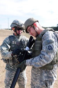 Sgt. 1st Class Somphot Hongtong, operations noncommissioned officer, Headquarters Support Company, U.S. Army North, explains the position of the aperture site on the M-16A2 Rifle Jan. 20, to Capt. Philip Lee, attorney, Army North, during the company’s advanced marksmanship training at the Camp Bullis Military Training Reservation in San Antonio. 
