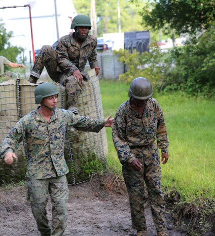 Chief Warrant Officer 2 Brent J. Patterson, the executive officer for Food Service Company, Combat Logistics Regiment 27, 2nd Marine Logistics Group encourages another Marine to push through the endurance course aboard Camp Lejeune, N.C., July 10, 2013. Patterson reminded his Marines to never forget their roots, and that being a Marine comes before being a food service specialist. (U.S. Marine Corps photo by Lance Cpl. Shawn Valosin)