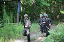 A team of Marines with Food Service Company, Combat Logistics Regiment 27, 2nd Marine Logistics Group runs through a clearing while conquering the endurance course aboard Camp Lejeune, N.C., July 10, 2013. The company split into multiple teams to work through obstacles of varying difficulties. (U.S. Marine Corps photo by Lance Cpl. Shawn Valosin)