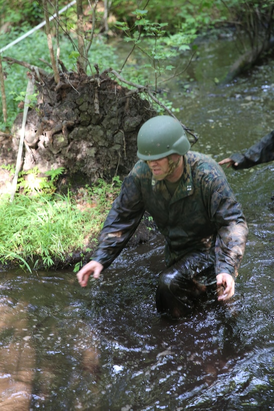 Capt. Joseph Fore, the company commander of Food Service Company, Combat Logistics Regiment 27, 2nd Marine Logistics Group, trudges through a stream while participating in a team-building exercise aboard Camp Lejeune, N.C., July 10, 2013. Marines from the company worked in teams to conquer an endurance course which ran through the swamps of the base. (U.S. Marine Corps photo by Lance Cpl. Shawn Valosin)