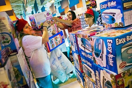 A military spouse receives assistance from volunteers during the Operation Homefront and Wal-Mart Foundation toy event for military families in the North Carolina National Guard Armory gymnasium in Fayetteville, N.C., Dec. 4, 2009.