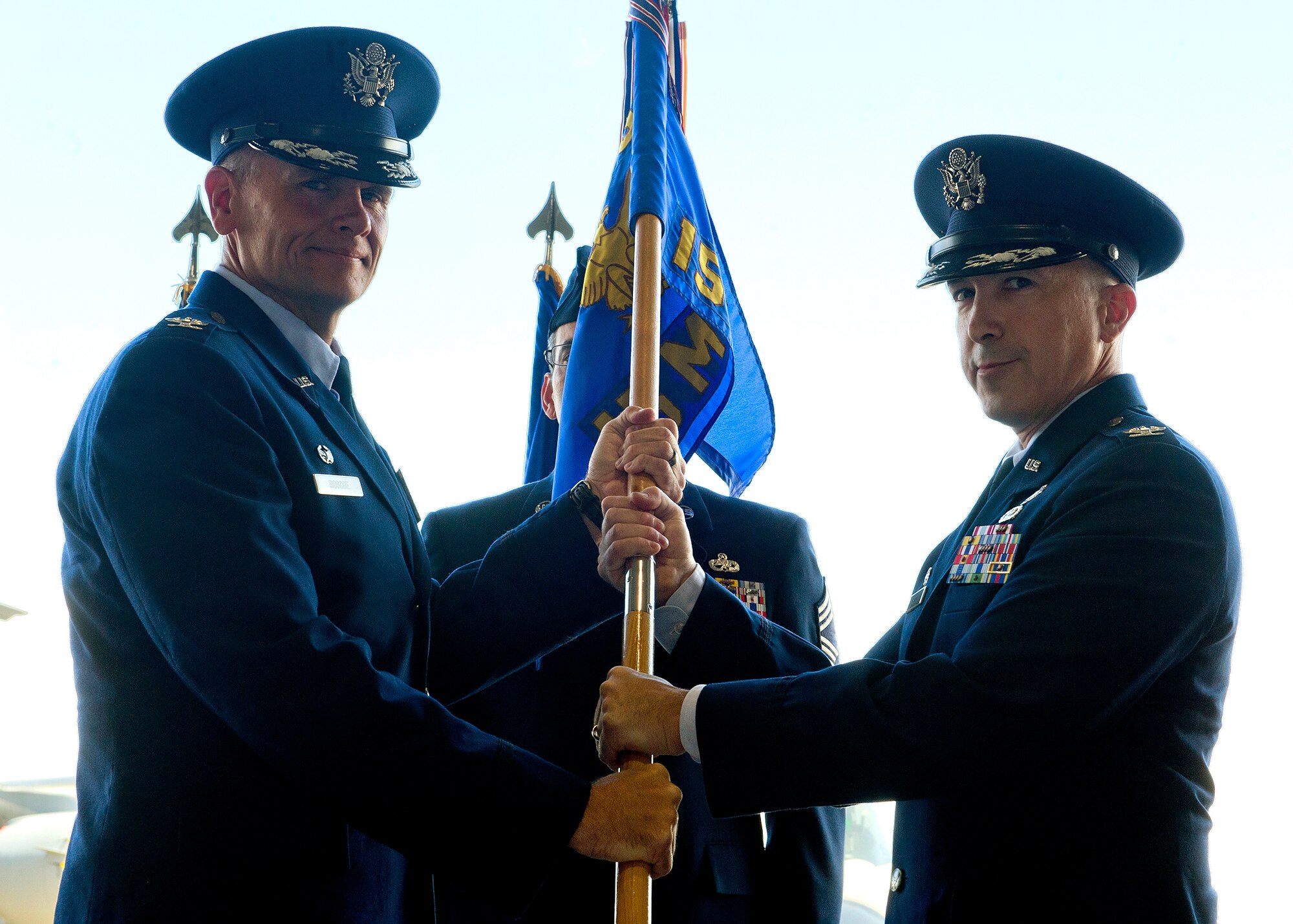 Col. Johnny Roscoe, 15th Wing commander, hands the 15th Maintenance Group guidon to Col. David Pastore, the new 15th MXG commander during a change of command ceremony at Hangar 19, Joint Base Pearl Harbor-Hickam, Hawaii, July 9, 2013. (U.S. Air Force photo/Tech. Sgt. Jerome S. Tayborn)