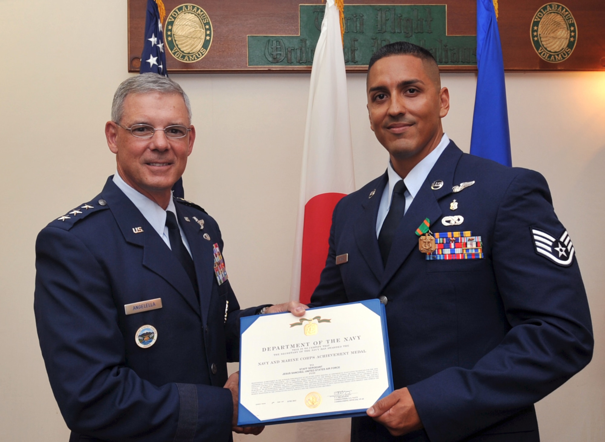 U.S. Air Force Lt. Gen. Salvatore Angelella, U.S. Forces Japan and 5th Air Force commander, awards U.S. Air Force Staff Sgt. Jesus Sanchez, 18th Aeromedical Evacuation Squadron air medical evacuation technician, the Navy and Marine Corps Achievement medal at the Officer’s Club on Kadena Air Base, Japan, July 10, 2013. While exercising at the Risner gym on Kadena Air Base, Japan, Sanchez, without hesitation, went to the aid of a Patrol Squadron 4-5 sailor who was suffering an apparent heart attack on April 5, 2013. By his rapid response, expertly administered first aid and sound judgment, Sanchez, along with U.S. Air Force Tech. Sgt. Kent Santos, 18th Aeromedical Evacuation Squadron air medical evacuation technician, undoubtedly saved the sailor’s life. (U.S. Air Force photo by Naoto Anazawa/Released)